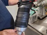 a man holding a black and silver blow dryer in a kitchen