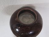 a brown vase sitting on top of a wooden table