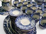 a lot of blue and white plates and cups on the table