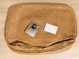 a brown purse with a tag on it sitting on a table