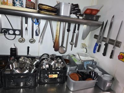 de nombreuses casseroles et poêles accrochées au mur de la cuisine