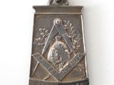 a silver pendant with a picture of a man on it