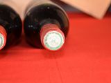 two bottles of wine sitting on a red table