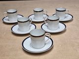 six cups and saucers are sitting on a table