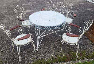 une table blanche et quatre chaises dans un parking