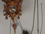 une horloge à coucou accrochée au mur par une chaîne