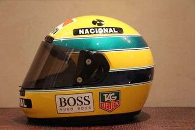un casque de course jaune et bleu posé sur une table en bois