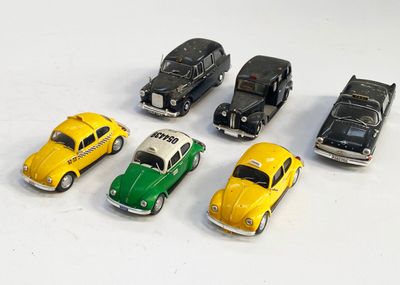 plusieurs petites voitures sont alignées sur une surface blanche