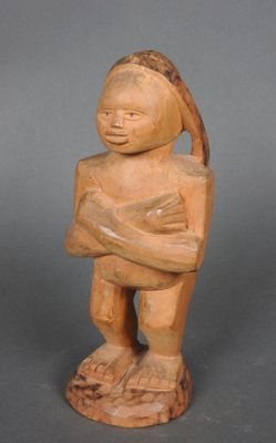 une vieille statue en bois représentant une personne tenant un bébé dans ses bras