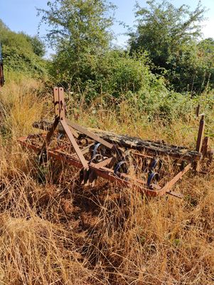 a plow that is sitting in the middle of a field