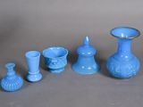several pieces of blue glass sitting on top of a gray surface