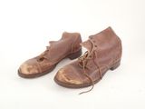 pair of brown leather shoes with laces on them on a white surface