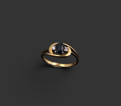 une bague en or sertie d'un diamant noir et de deux diamants blancs