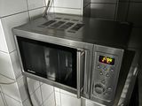 a microwave that is on top of a shelf in a kitchen