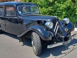 a old black car parked on the side of the road