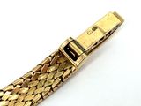 a close up of a gold watch band on a white surface
