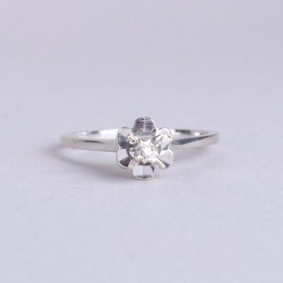 gros plan d'une bague en diamant sur une surface blanche