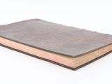an old book that is sitting on a white surface