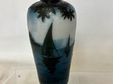 a blue vase with a sailboat on it on a clear shelf