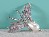 an image of a white pearl and silver broochle on a table