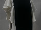 black and white dress on a mannequin stand against a white backdrop