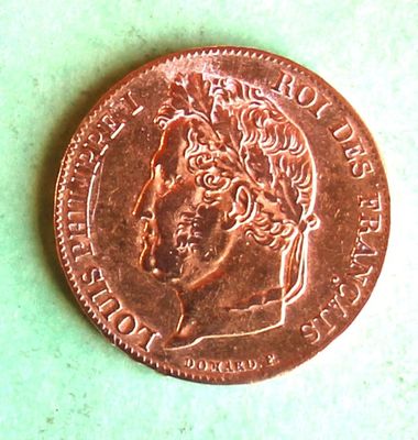 a close up of a penny on a table with a green background