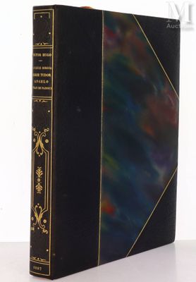an old book sitting on top of a table next to a white wall