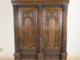 une grande armoire en bois ornée de sculptures sur le dessus