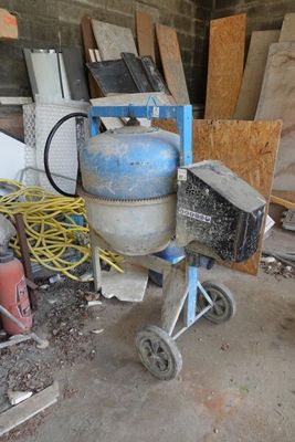 une bétonnière dans un garage rempli d'outils