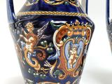 pair of blue and gold vases sitting on top of a white surface