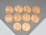 several gold coins are arranged in a triangle on a gray surface