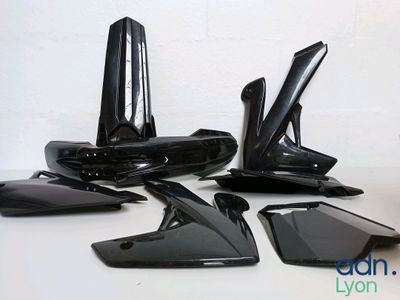 four pieces of black plastic on a white table
