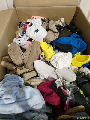a cardboard box filled with lots of clothes and shoes