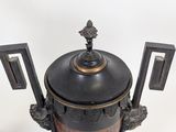 a black and gold vase on a white surface