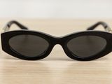 black cat eye sunglasses on a wooden table with a white background