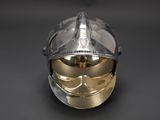 a silver helmet with a gold mask on it