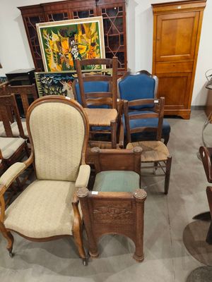 de nombreuses chaises et tables dans une pièce où est accroché un tableau au mur