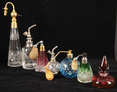 five different colored glass vases and a brass faucet on a black background