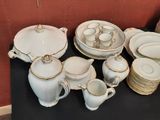 a black table with a bunch of white and gold china