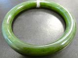 a green bracelet that is on a black table
