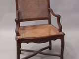 une vieille chaise en bois avec un dossier et une assise en rotin
