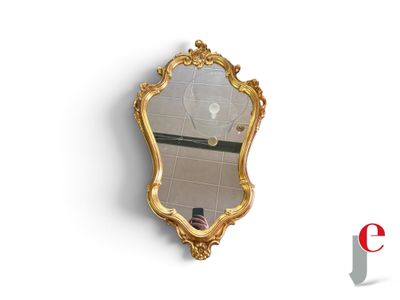 a gold mirror on the wall with a reflection of a person taking a selfie