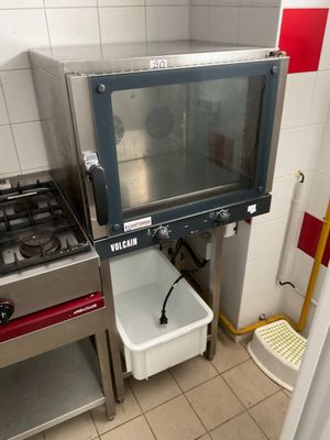 an image of a commercial kitchen with a stove and a microwave