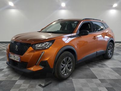 Le SUV orange est garé sur un sol en carrelage à damier.