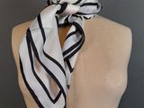 white and black striped scarf on a mannequin torso
