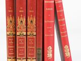Plusieurs livres rouges sont empilés les uns sur les autres sur une surface blanche