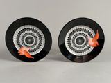 pair of black and white plates with orange fish on them