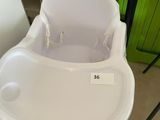 a white high chair with a plastic tray on it