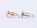 a pair of gold and silver rings with a blue topaz stone