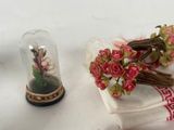 a small vase with flowers inside of it next to a napkin